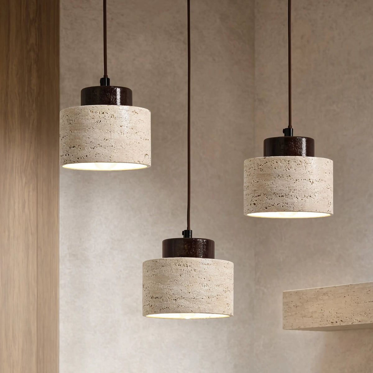 Trio de suspensions en travertin beige, matière en lumière rasante