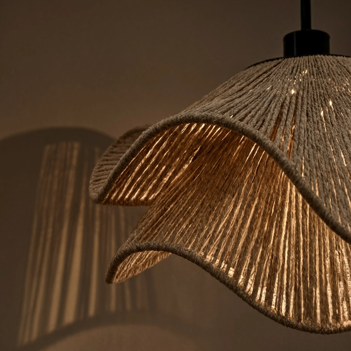 Gros plan sur la suspension Naxos en corde de jute et sa lumière chaude